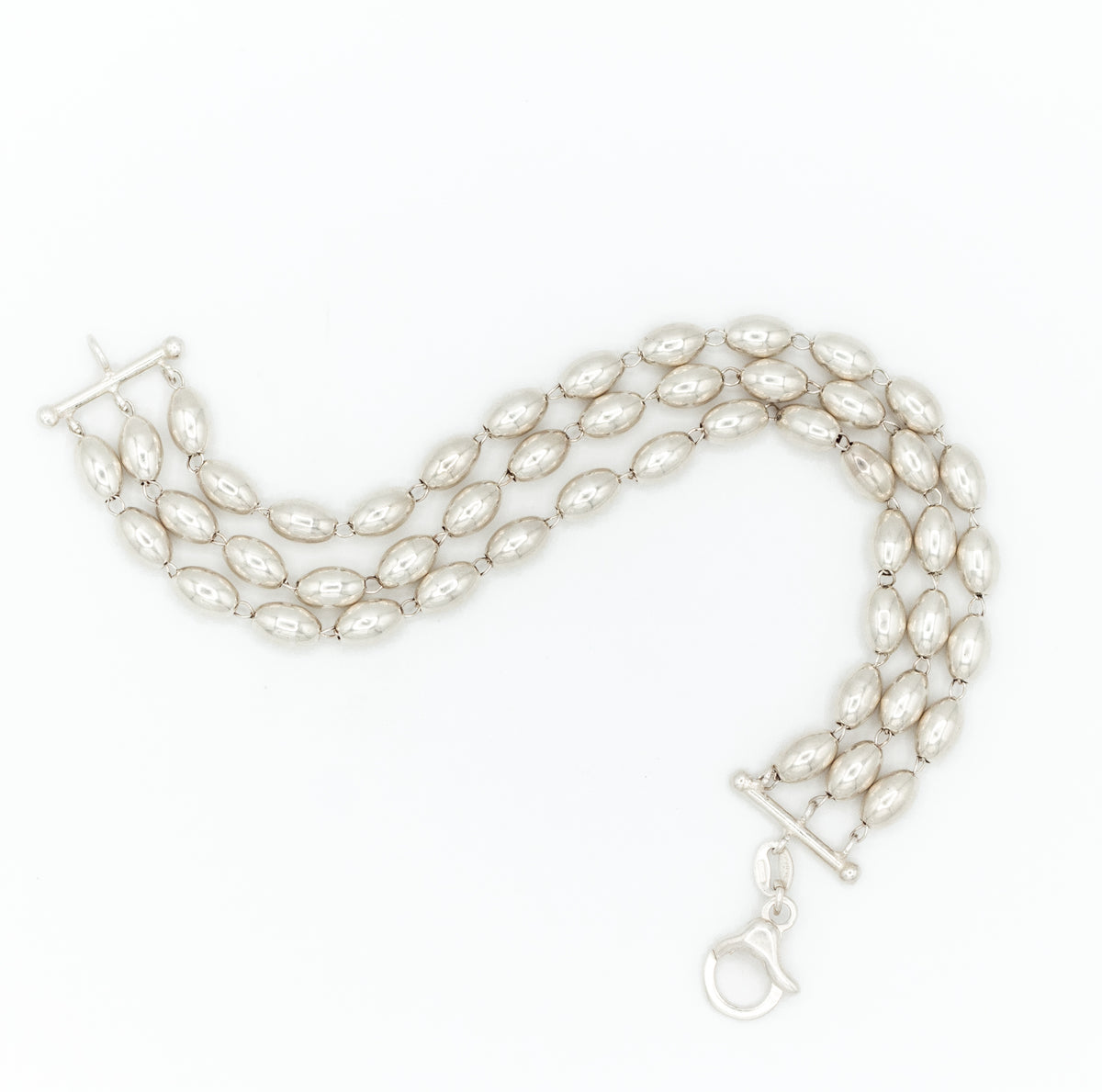 A multi-strand pearl bracelet with a silver-tone toggle clasp and lobster clasp, displayed on a clean white background.